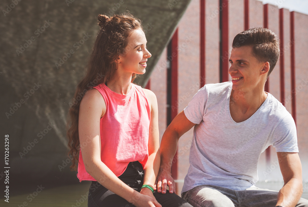 Young couple sitting outdoor and talking, happiness concept