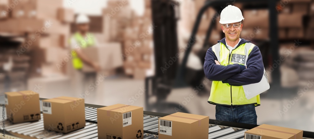 Composite image of worker wearing hard hat in warehouse