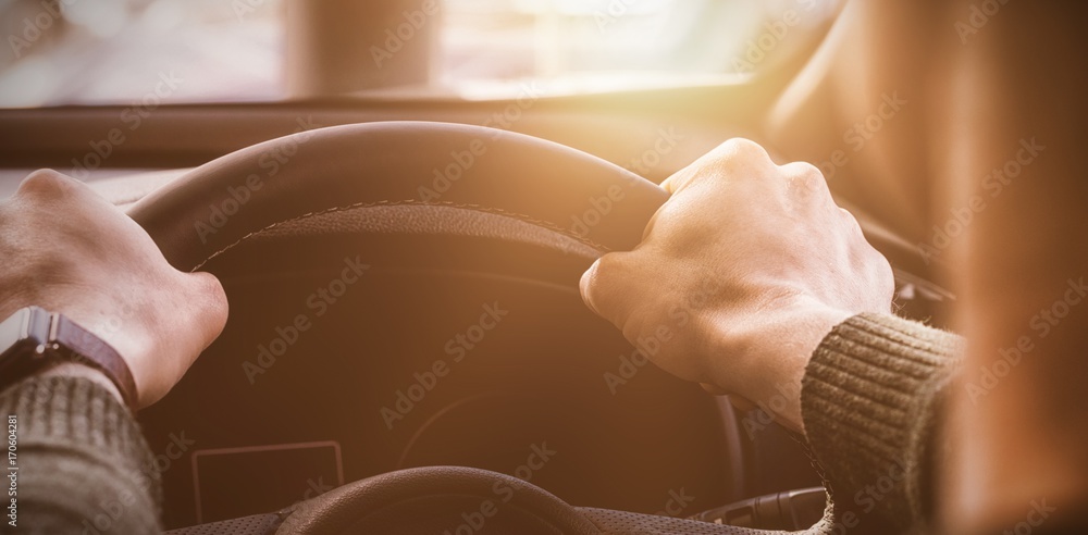 man holding the steering wheel of his car