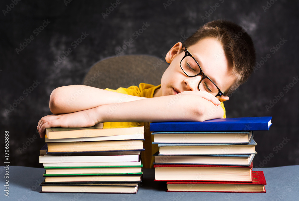 Boy sleepeing on top of books