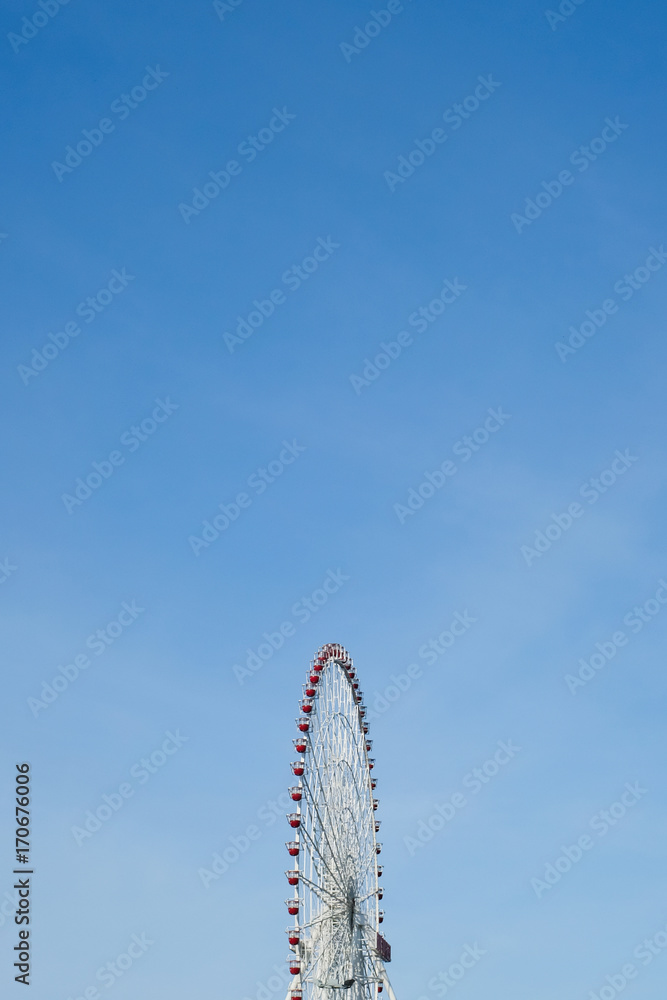 Retro colorful ferris wheel over the blue sky background.