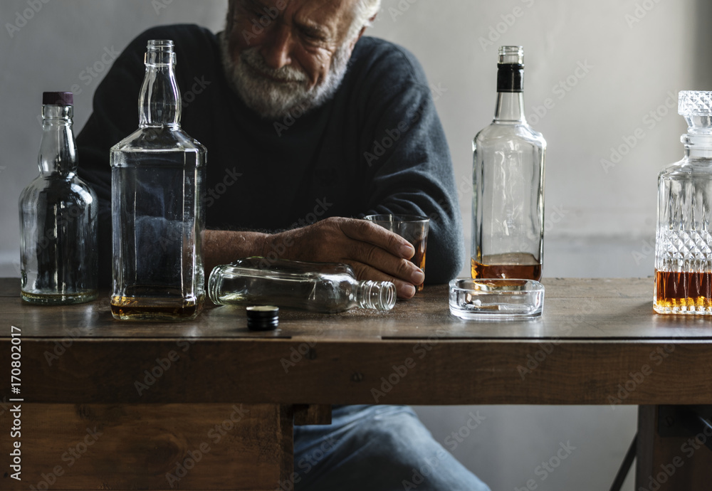 Elderly man sitting drinking whiskey alcoholic addiction bad habit