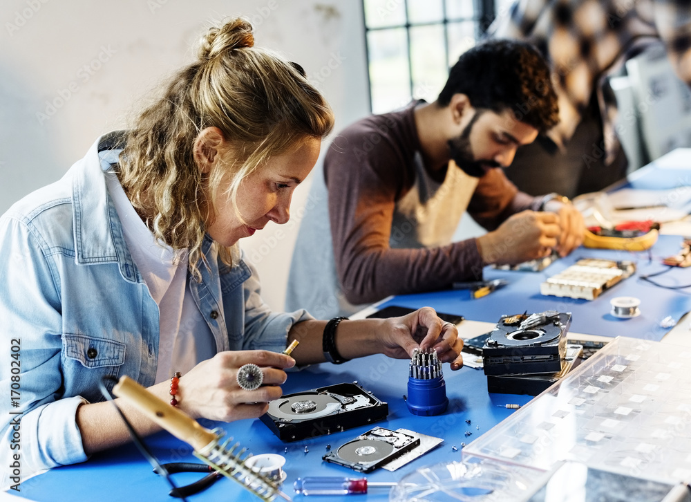 Side view of technicians working on computer electronics parts