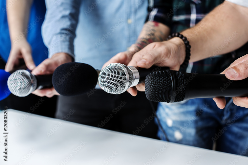 Hands holding microphone for an interview