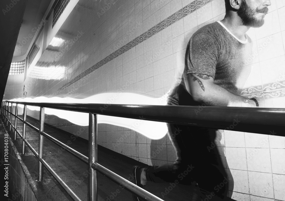 Man in a running movement with long exposure light at his back