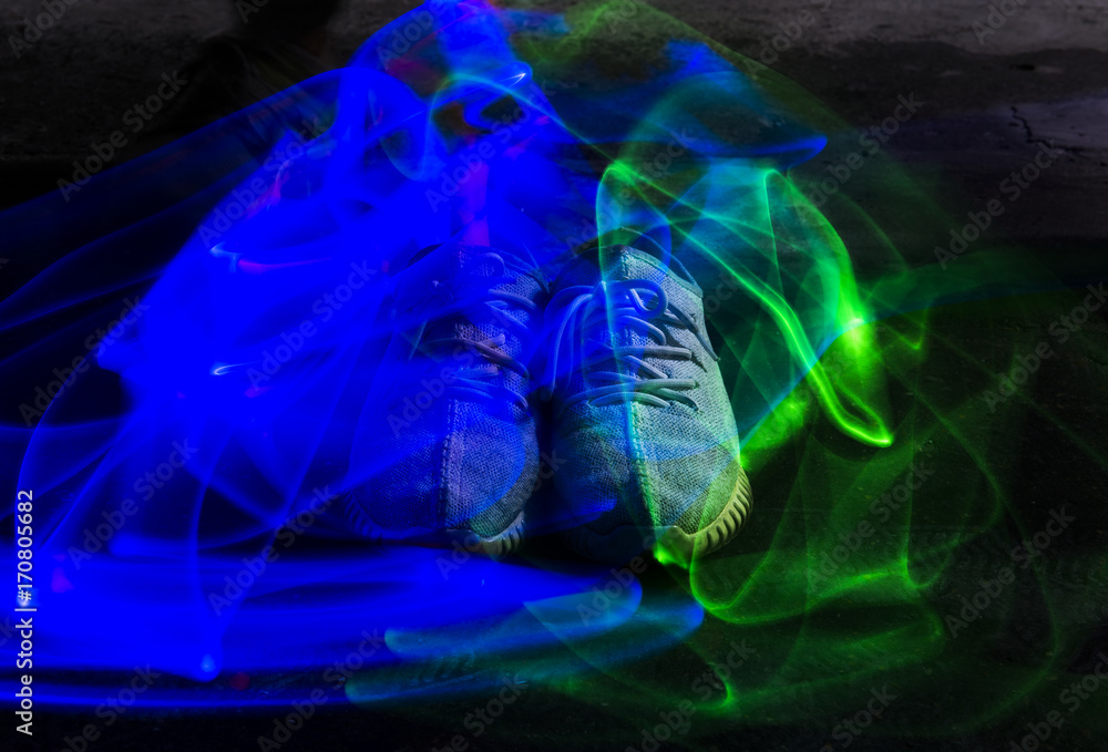 Long exposure blue and green light lines movement over sneakers