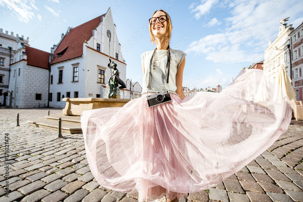 Porait of a young woman tourist traveling on the old Market sqaure in Poznan city during the morning