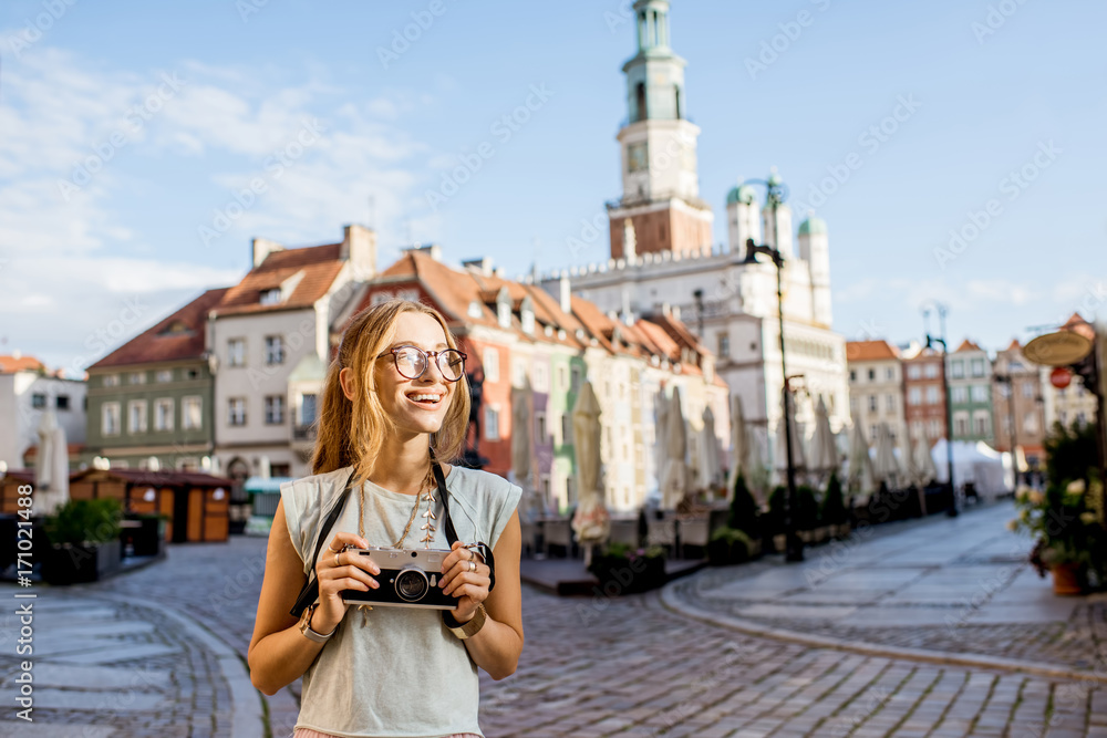 Porait of a young woman tourist traveling on the old Market sqaure in Poznan city during the morning