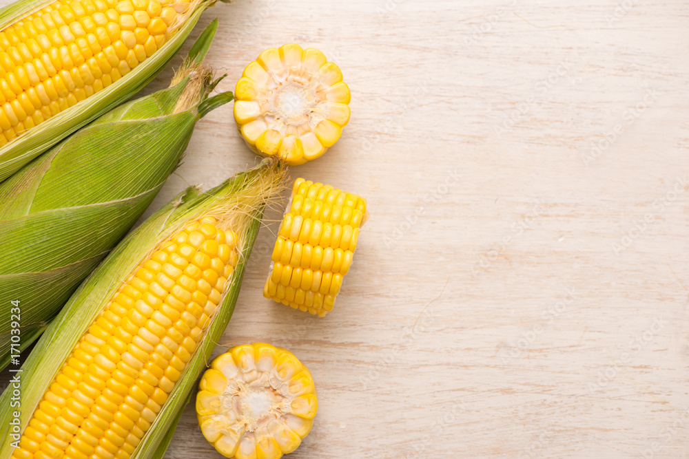 Sweet corns. Fresh corn on cobs on wooden table.