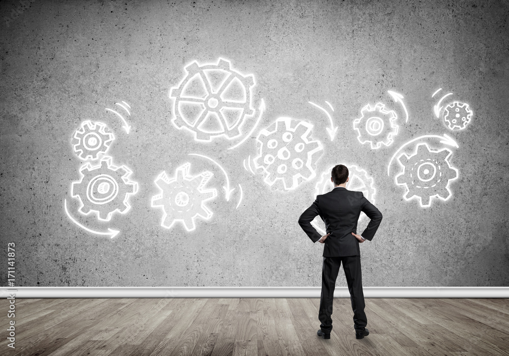 Cogwheel engine drawn on concrete wall as symbol for teamwork and cooperation