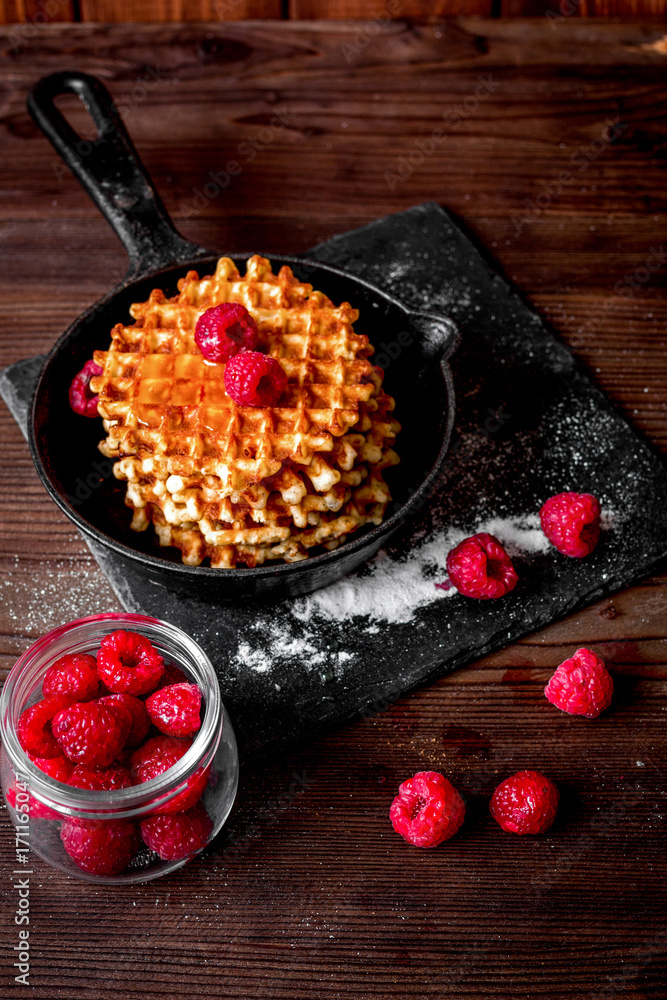 waffles with raspberries on wooden background