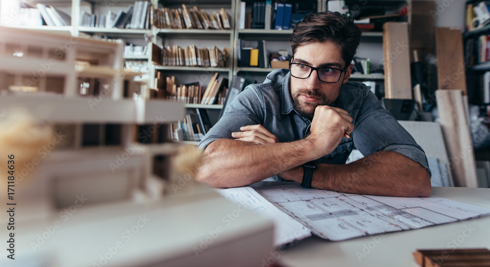 Architect looking at house model on desk