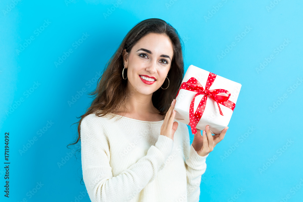 Happy young woman holding a gift box