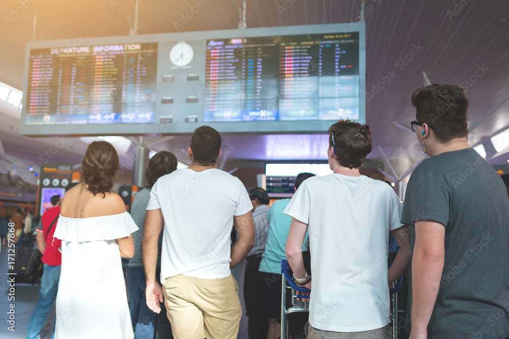 Young traveler in airport near flight timetable