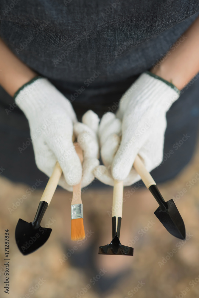 年轻女子拿着园艺工具的特写手