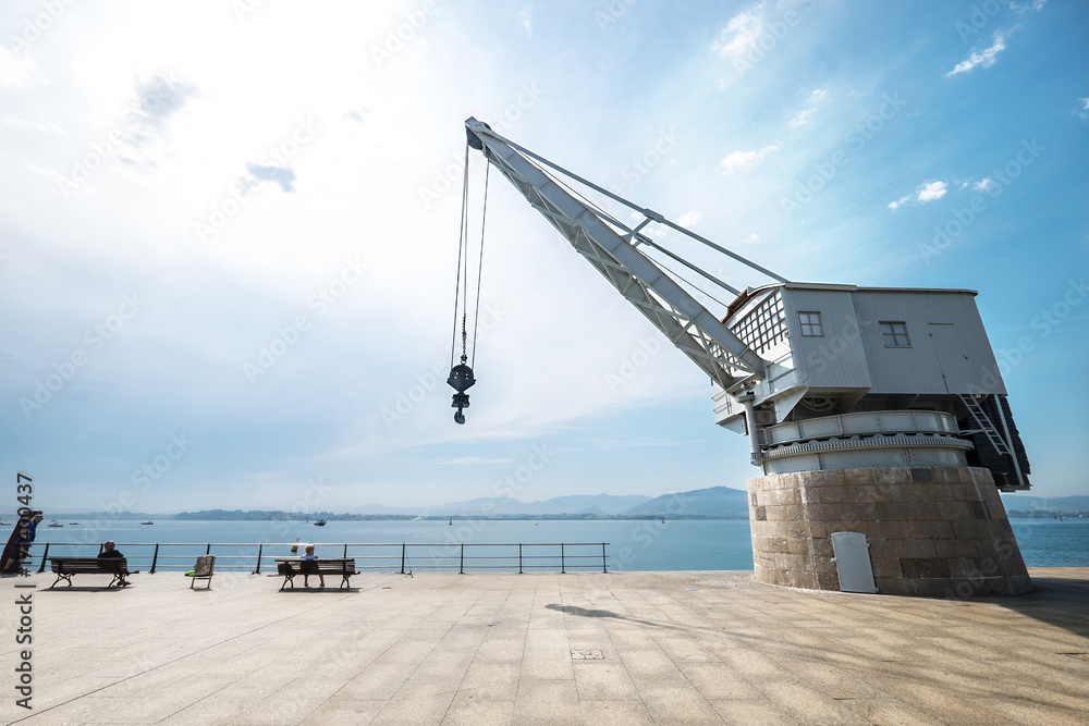 Santander (Spain) sea industrial embankment crane wide angle view.