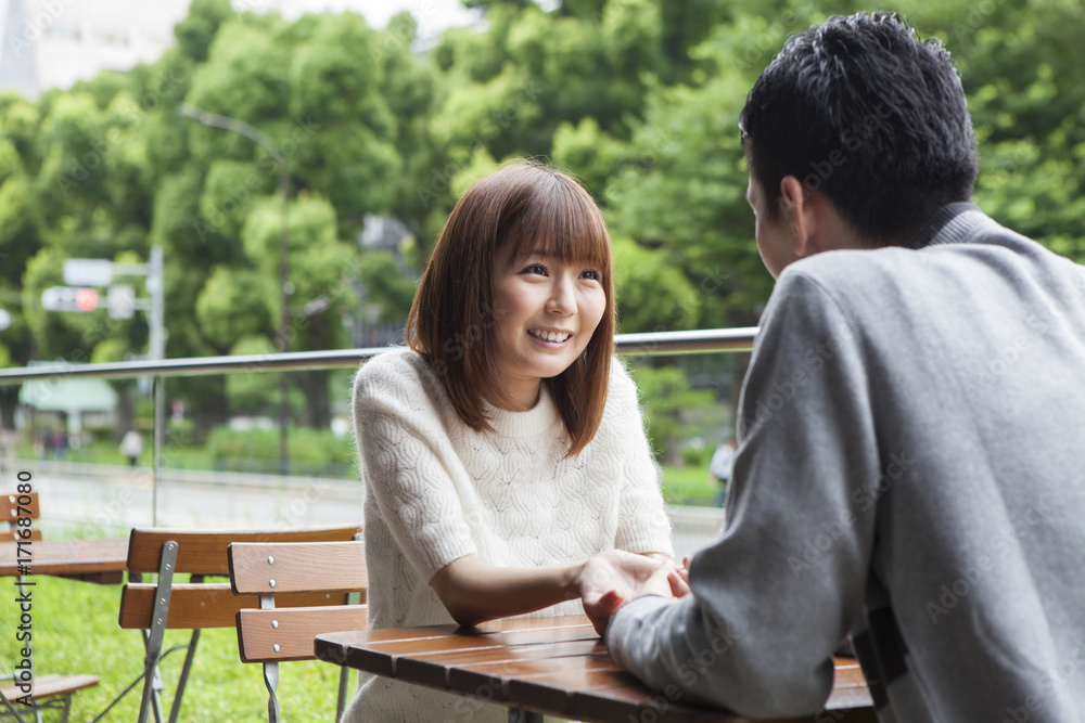 A couple talking while staring at the cafe terrace