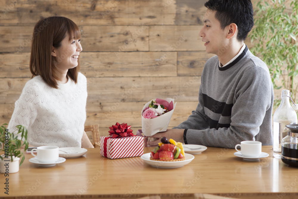 Man giving bouquet and present to woman