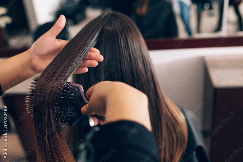 Female hair stylist working on a woman s hair at salon