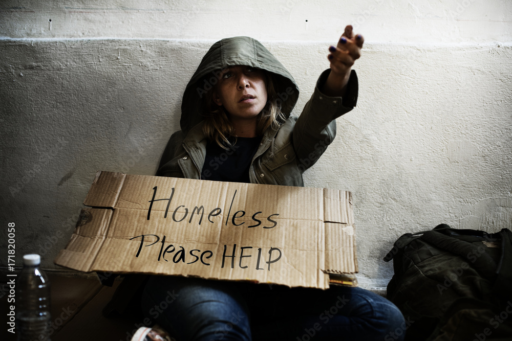 Homeless man holding helping board on the street 