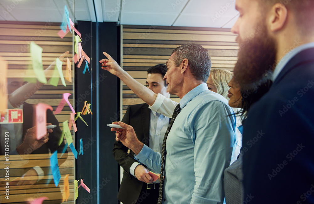 Business people pointing at sticky notes