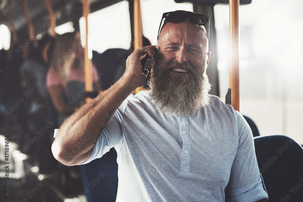 Laughing man standing in a bus talking on the phone