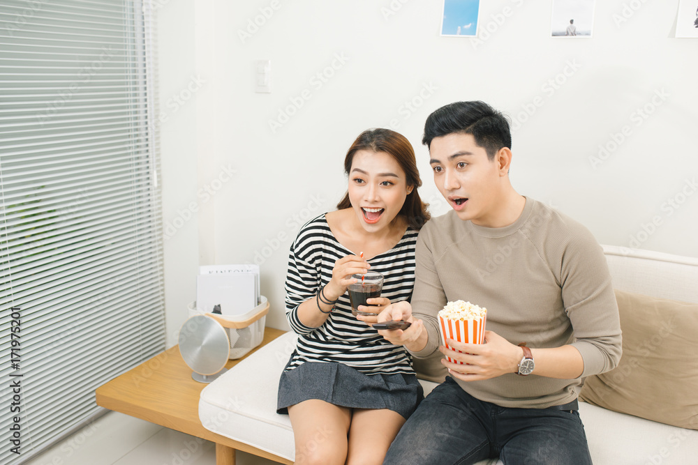 Relaxed young couple watching television in their living room