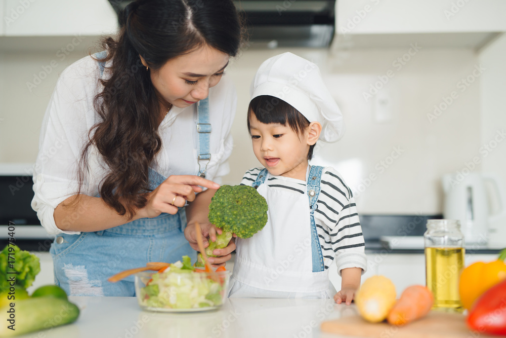 厨房里有一个幸福的家庭。母女俩正在准备蔬菜和水果。