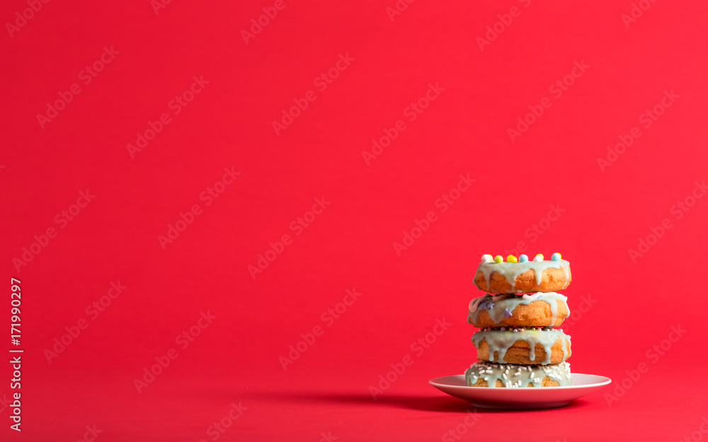 Colorful glazed donuts on a bright red background