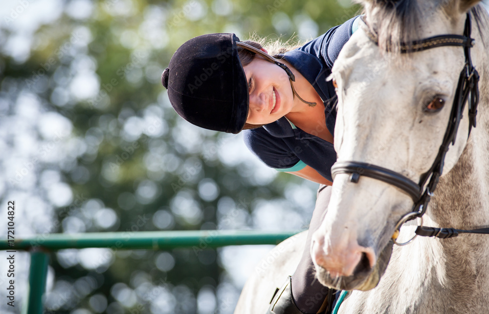 Woman riding a horse on paddock, horsewoman sport wear