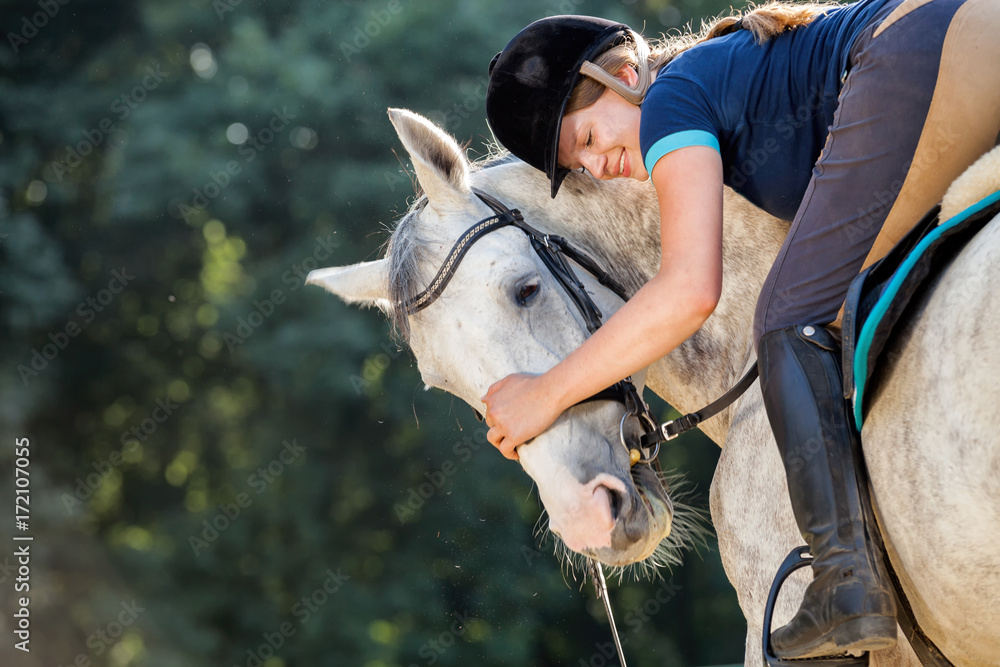 Woman riding a horse on paddock, horsewoman sport wear