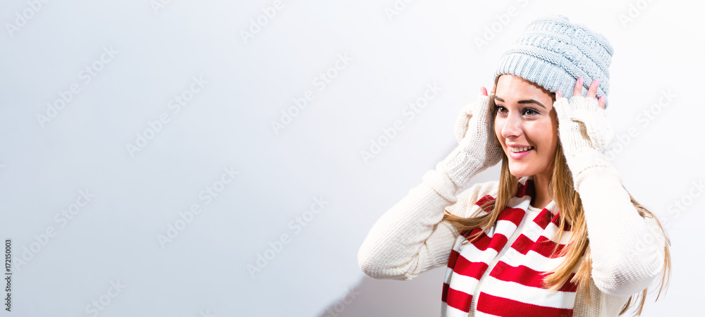  Happy young woman in winter clothes on a blue background