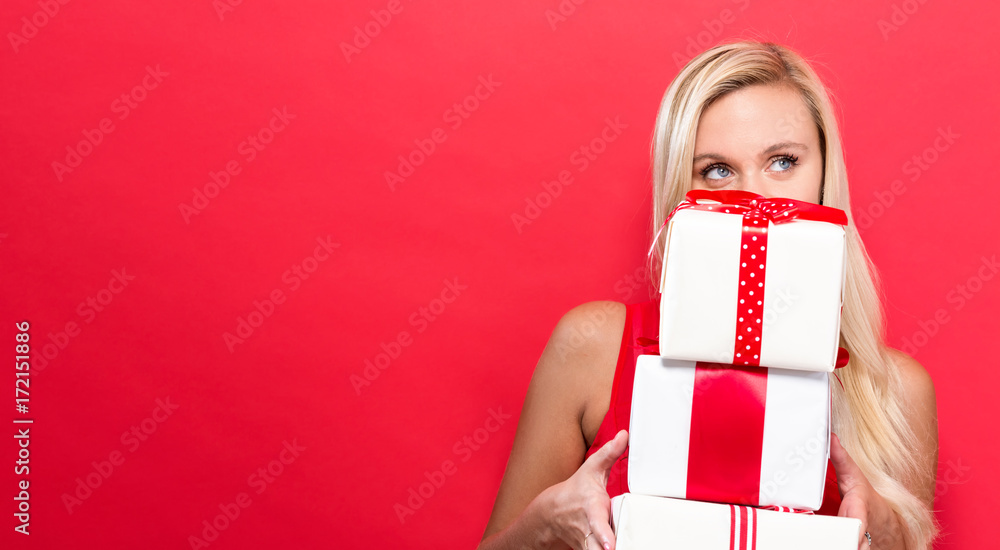 Happy young woman holding a stack of gift boxes