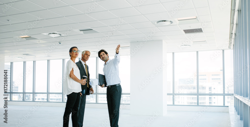 Real estate agent showing new office space to clients