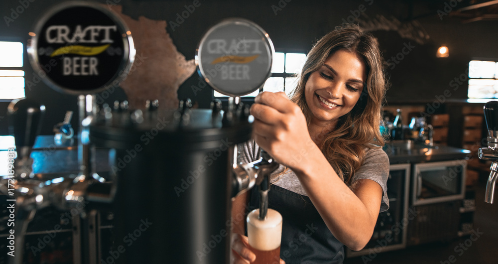 女调酒师在酒吧里敲精酿啤酒