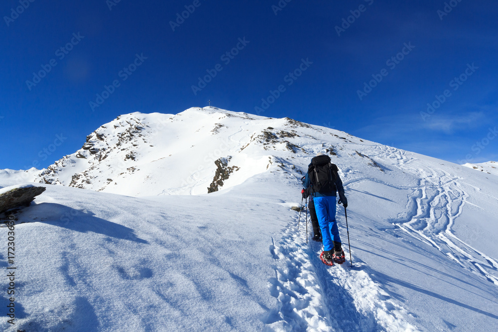 一群人穿着雪鞋徒步旅行，在澳大利亚斯塔拜阿尔卑斯山与山顶交叉处欣赏山雪全景