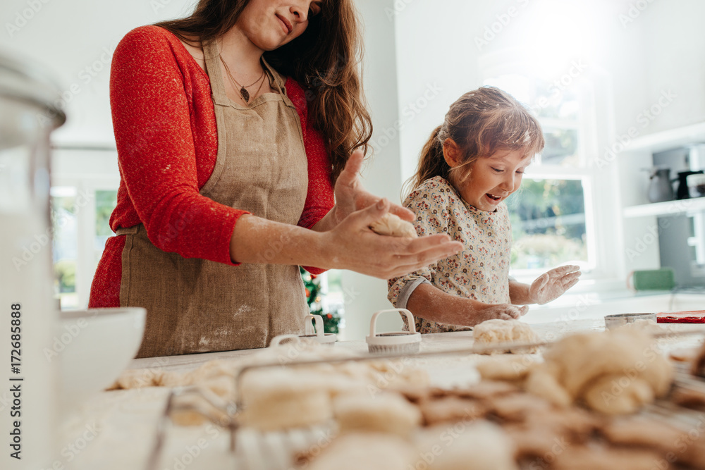 Mother and child making cookies for Christmas.