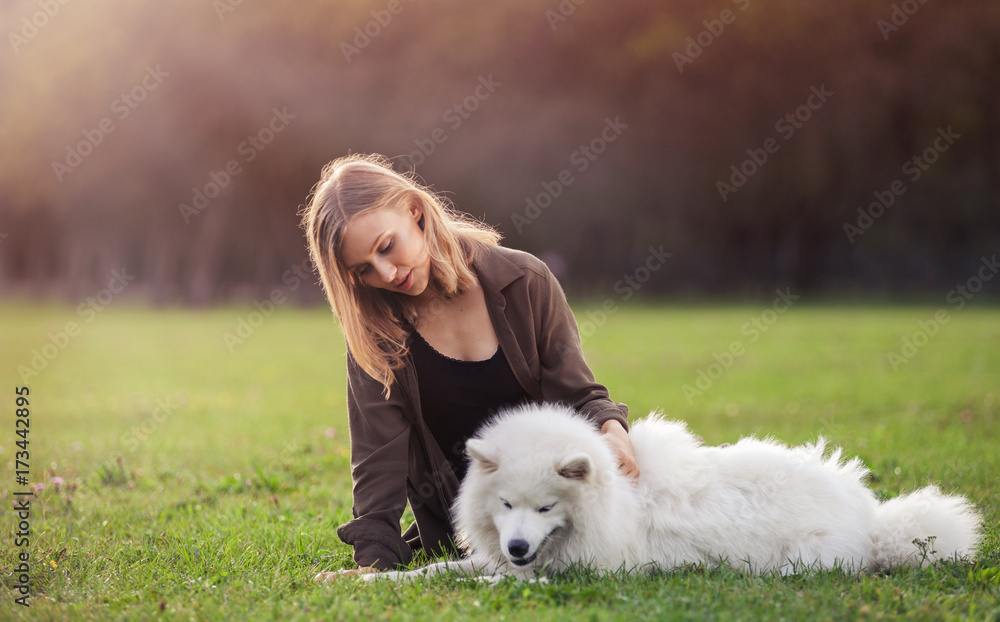 Pretty girl with dog on grass