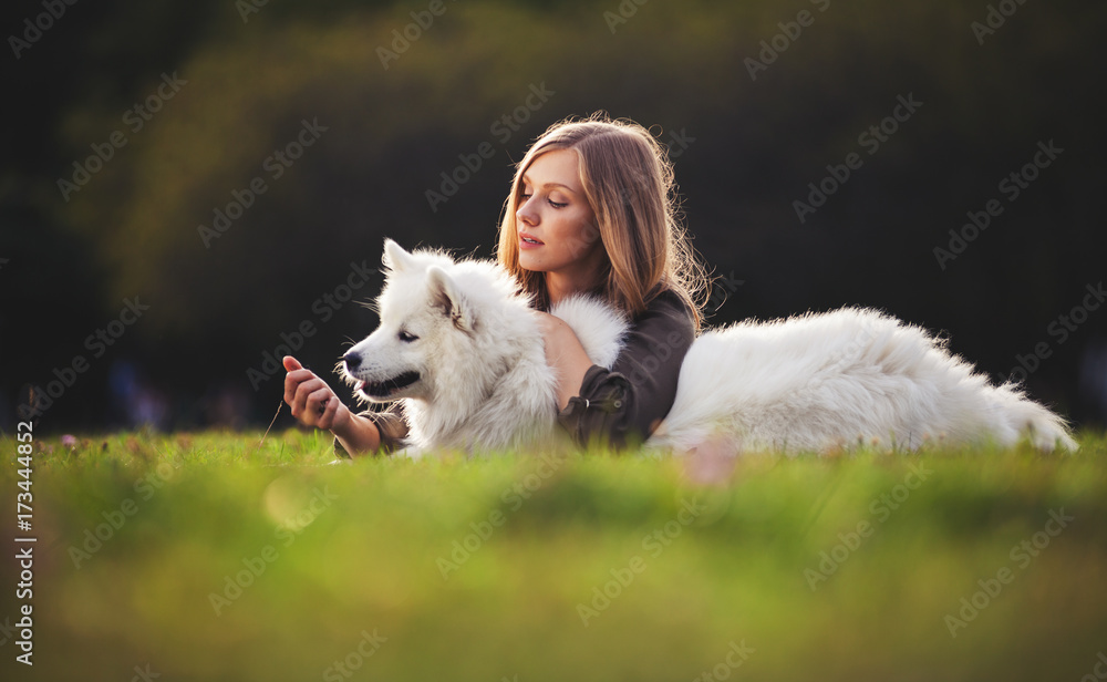 Pretty girl playing with dog on grass at the park