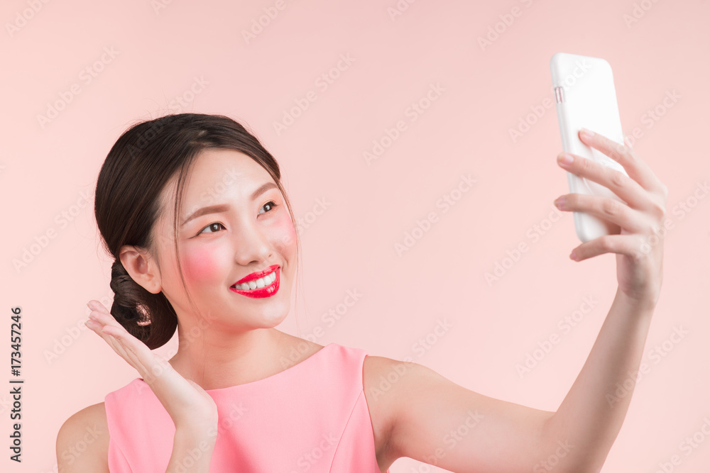 Smiling lovely active asian girl taking selfie photo.