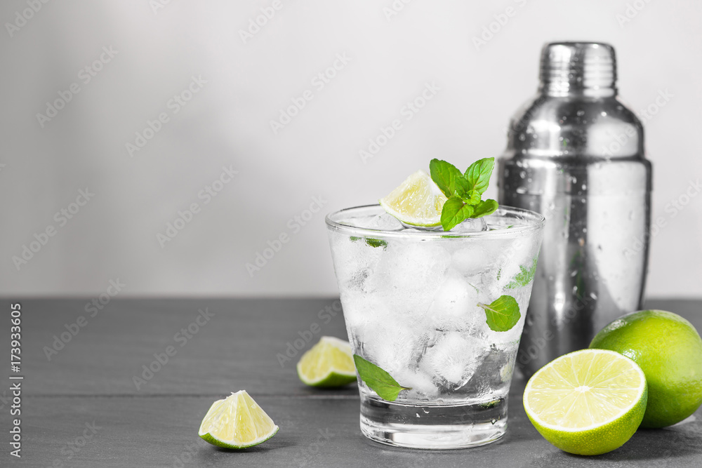 Mojito cocktail with lime and mint in glass on a grey stone background