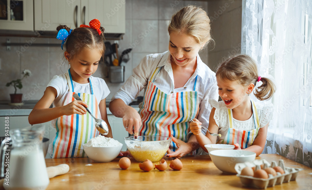 Happy family mother and children twins   bake kneading dough in kitchen