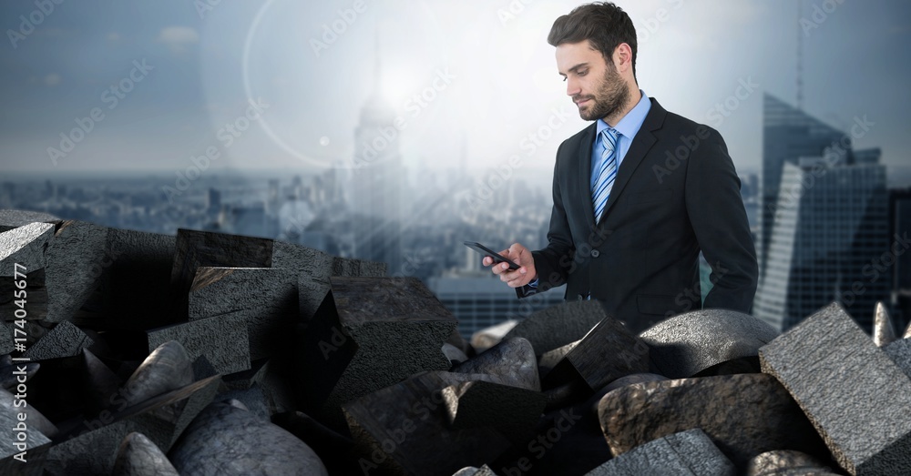 Dark bricks in pile with businessman holding phone over city