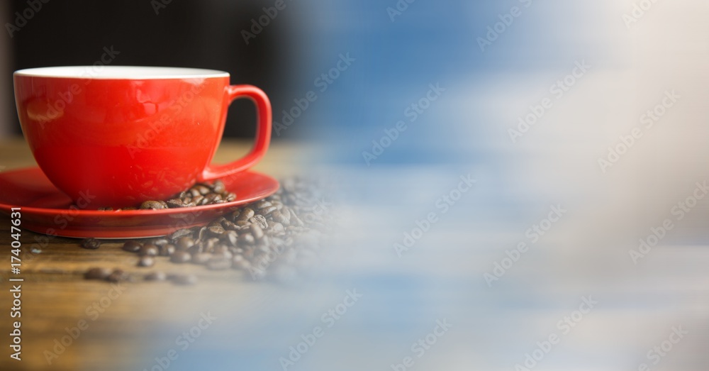 Red coffee cup with beans and blurry sky transition