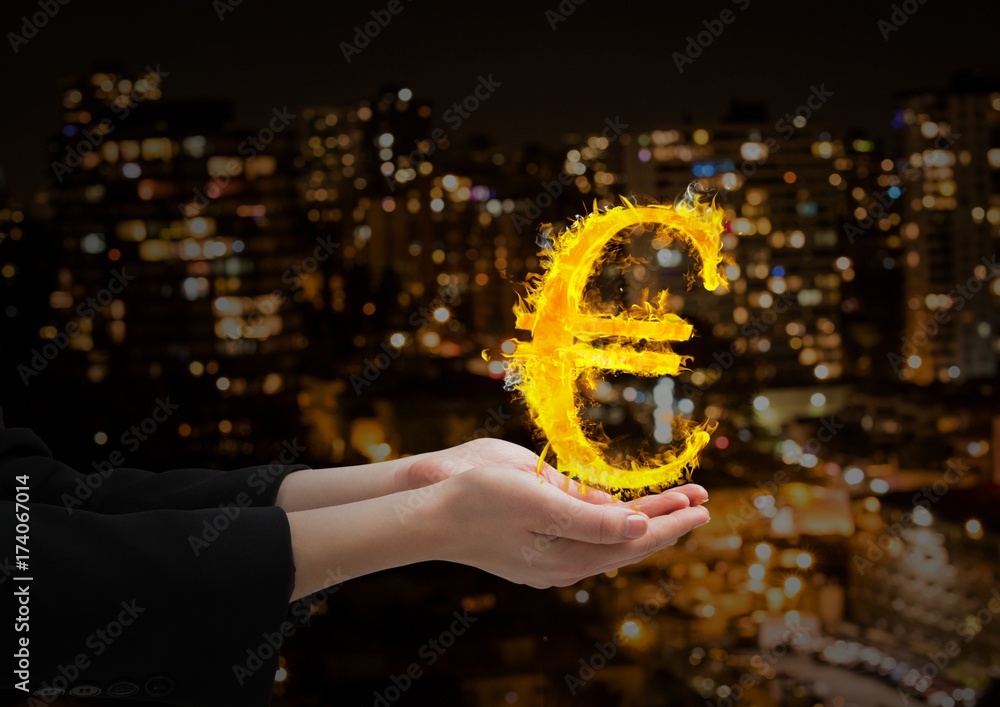 hand with euro fire icon over in front of the blurred city at