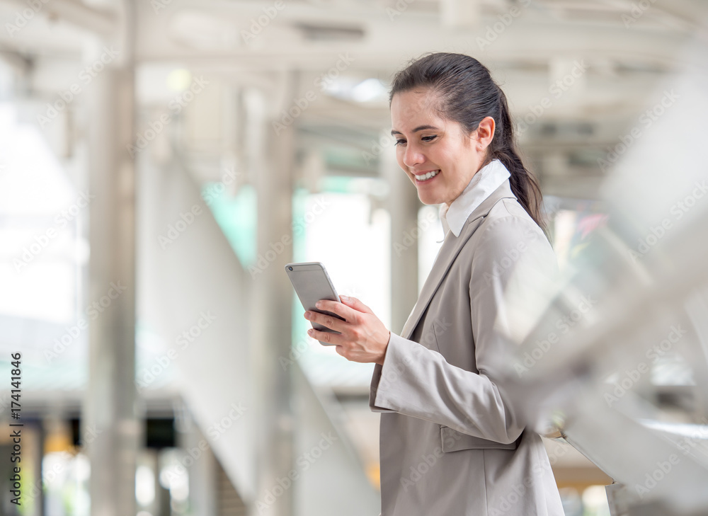 Portrait young caucasian businesswoman 20-30s holding smart phone/cell phone/mobile in formal suit a