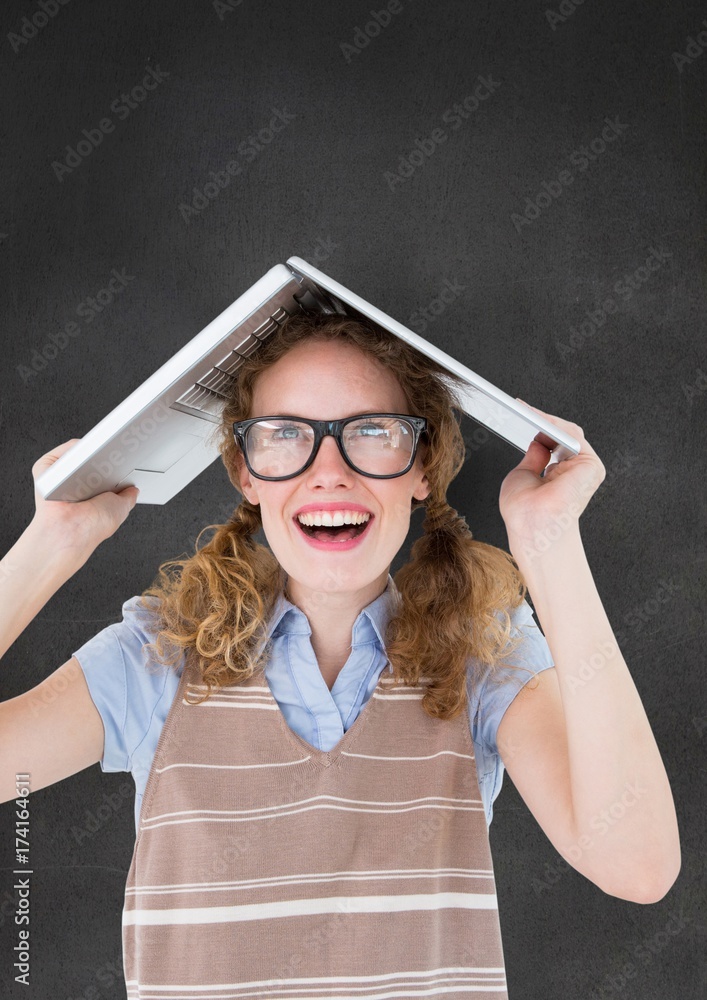 Nerd woman with laptop on head against grey wall