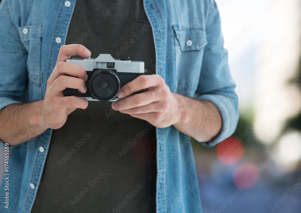 photographer hands with vintage camera ( foreground) in the city