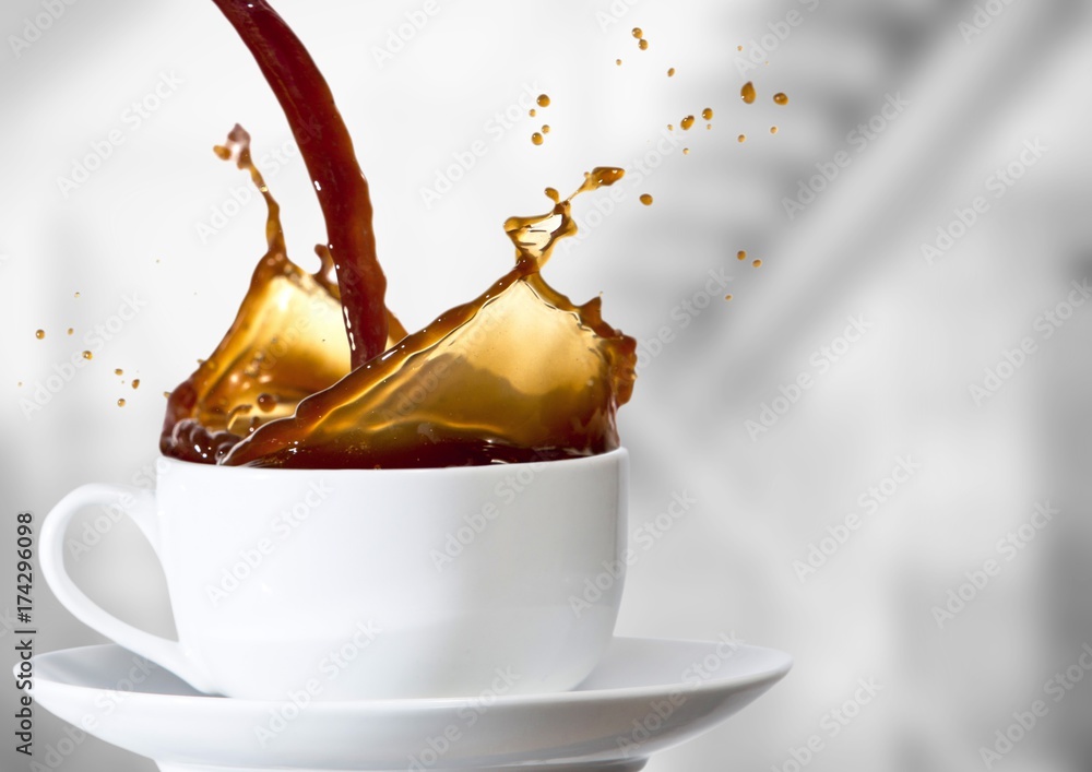 Coffee being poured into white cup against blurry grey stairs