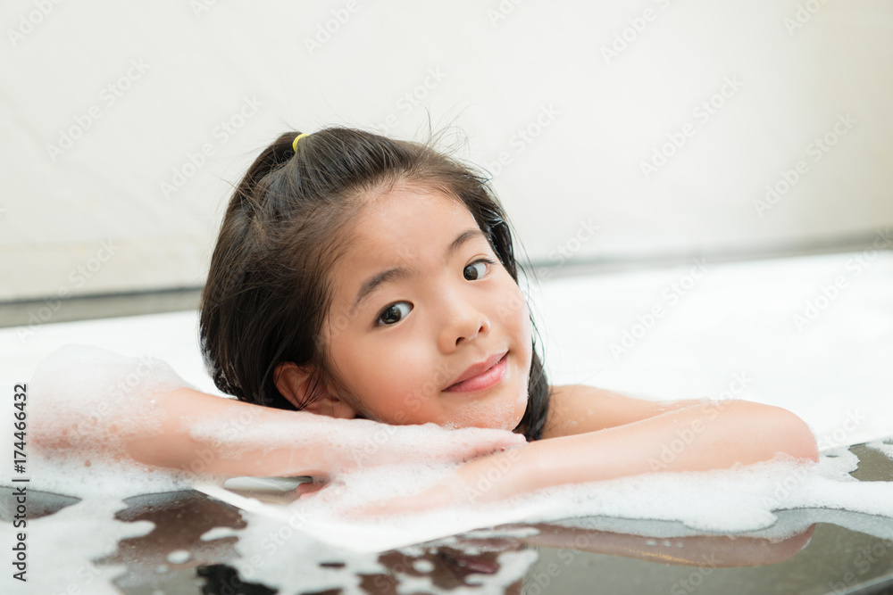 happy lovely little girl washing body at bathroom